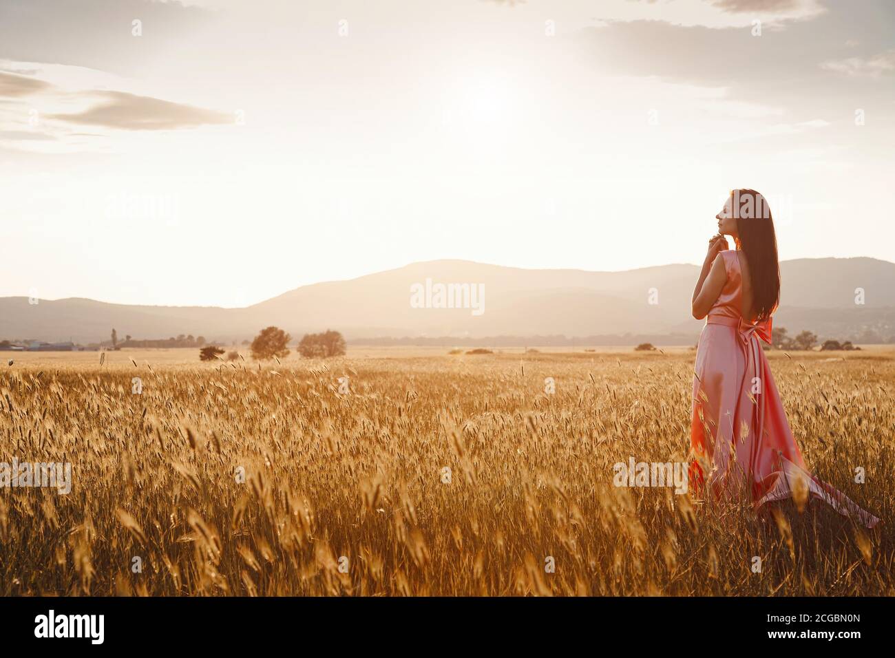 girl dancing in a field in a beautiful pink dress at sunset. ideal for ...