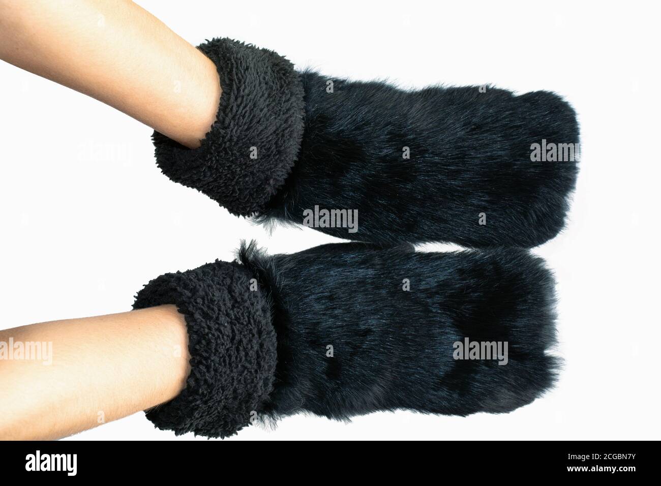 women hands wearing black fur mittens isolated on white background
