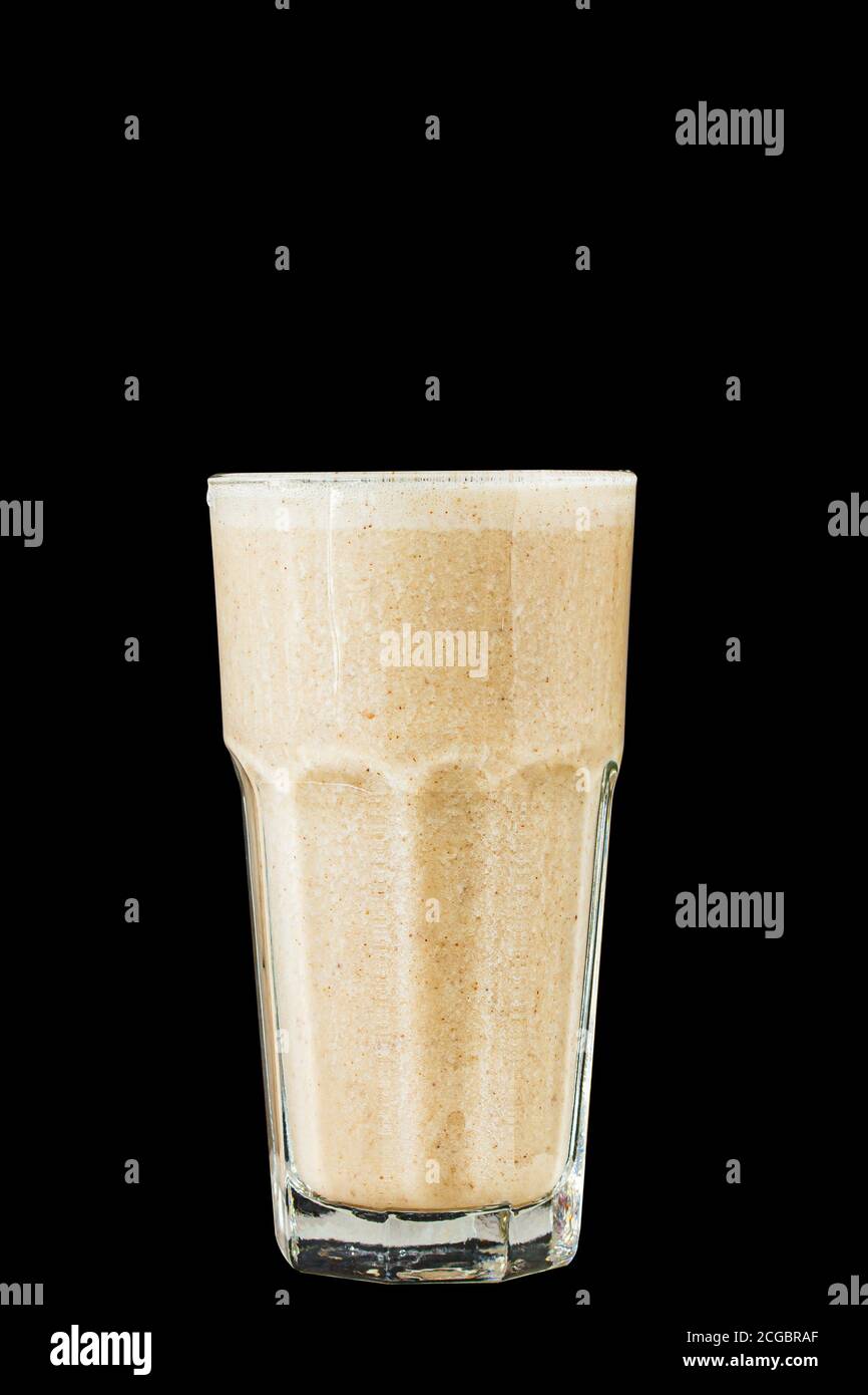 Brown Smoothie or cocktail with coffee and yogurt in a large glass glass on a black background, isolated. Stock Photo