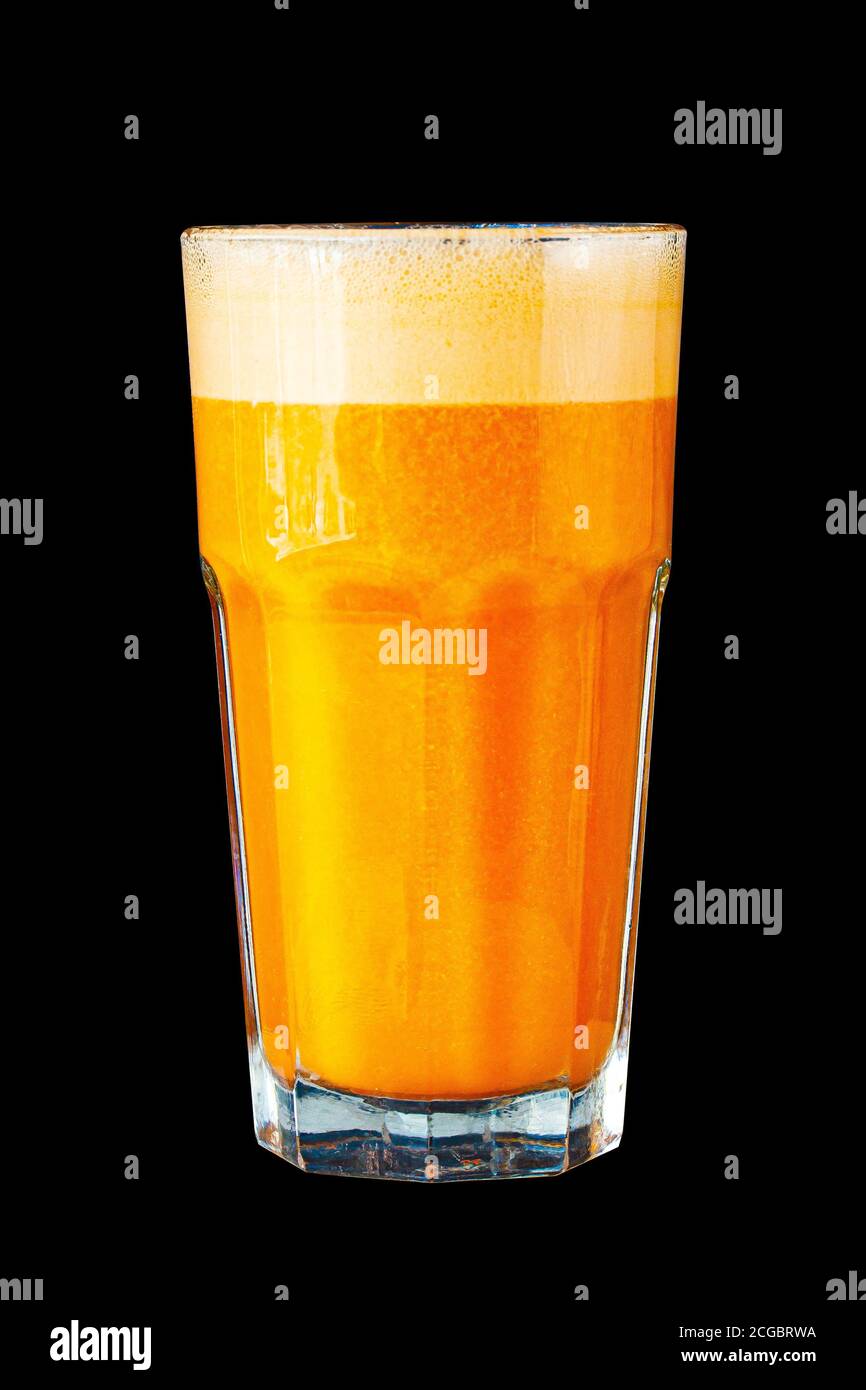 Yellow smoothie (orange, mandarin) in a large glass cup against a dark wall. Stock Photo