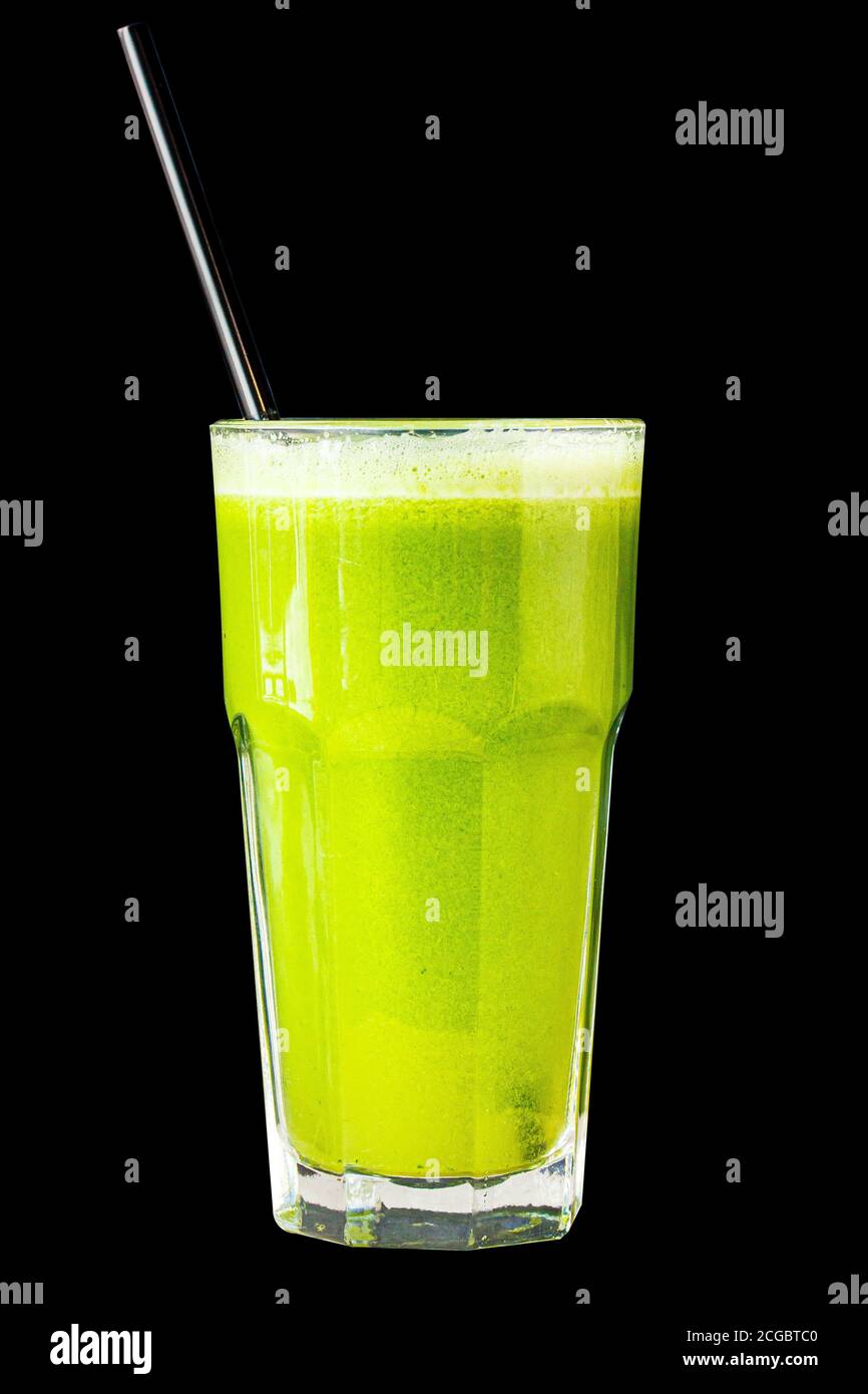 Green smoothie made from herbs and vegetables in a large glass glass on a black background, isolated Stock Photo