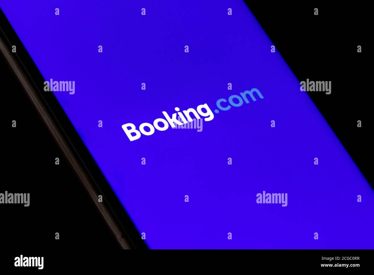 Booking.com logo displayed on the smartphone, travel and hotel industry crisis due to Covid or Coronavirus pandemic, restructuring, with finger Stock Photo