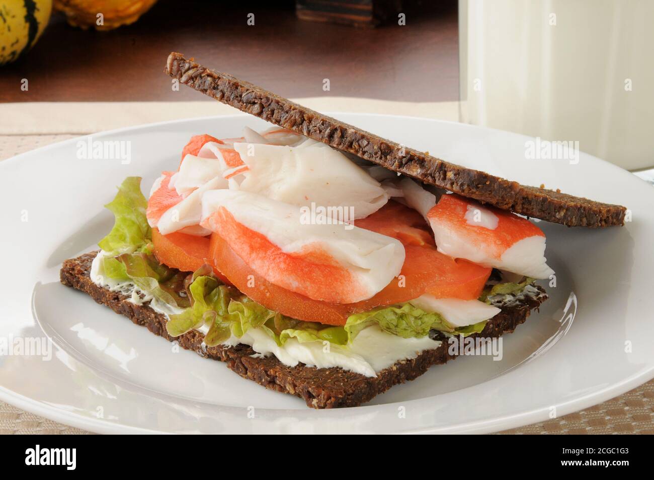 Crab and tomato sandwich on thin sliced pumpernickel bread Stock Photo