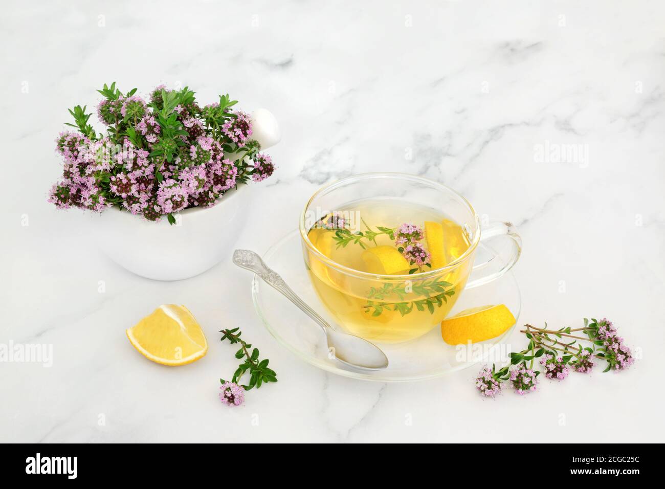 Thyme herb for cold & flu virus remedy in a mortar with pestle and hot drink with lemon. Immune boosting & is very high in antioxidants & vitamin c. Stock Photo