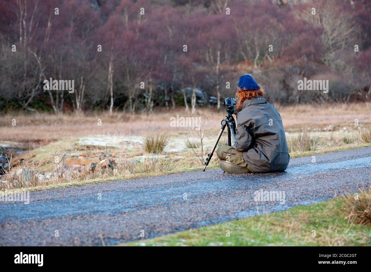 A young photographer composing a photograph in a wintery landscape. Stock Photo