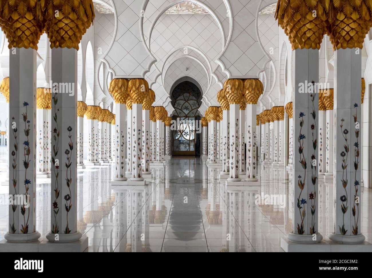 A day shot from inside the archway inside the  Sheikh Zayed Grand Mosque, Abu Dhabi. This includes its architectural features of marble columns with marble floral design and date palm capitals. Mosque completed 2007. Stock Photo