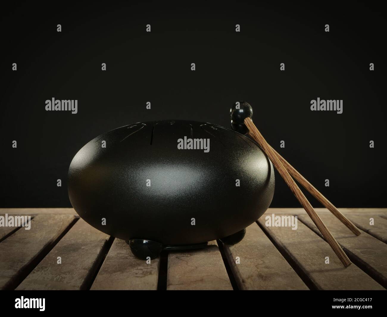 Steel tongue drum rare music playing instrument, made from propane tank and also known as tank drum or hank drum similar to Pantam.  On wooden surface Stock Photo