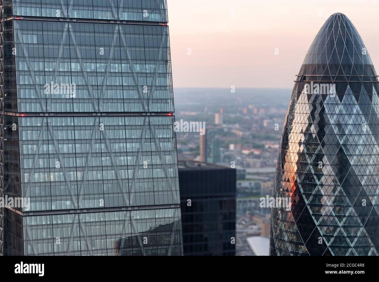A sunset shot of the Gherkin (30 St Mary Axe) and adjacent Leadenhall Building tower. Shot taken at sunset from the sky garden viewing deck. Gherkin completed 2003 Stock Photo