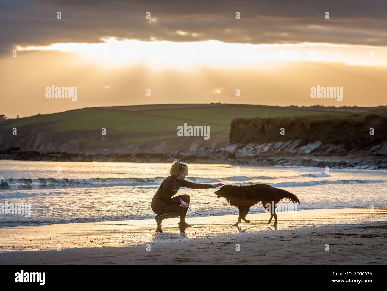 Garrylucas, Cork, Ireland. 09th September, 2020. A girl plays with her dog as the sun goes down at Garrylucas Beach, Co. Cork, Ireland.- Credit; David Creedon / Alamy Live News Stock Photo