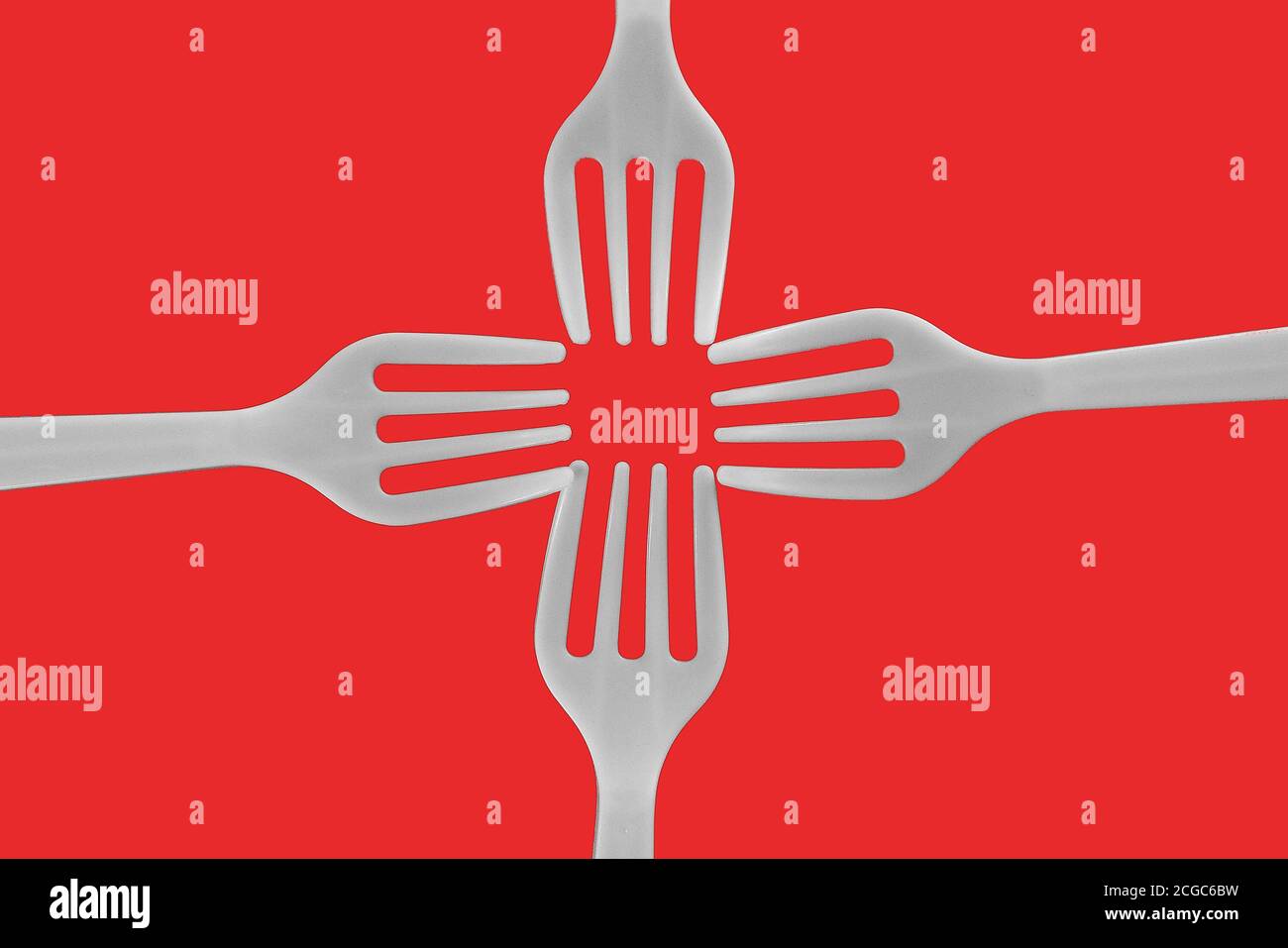 four plastic white forks on a red background Stock Photo