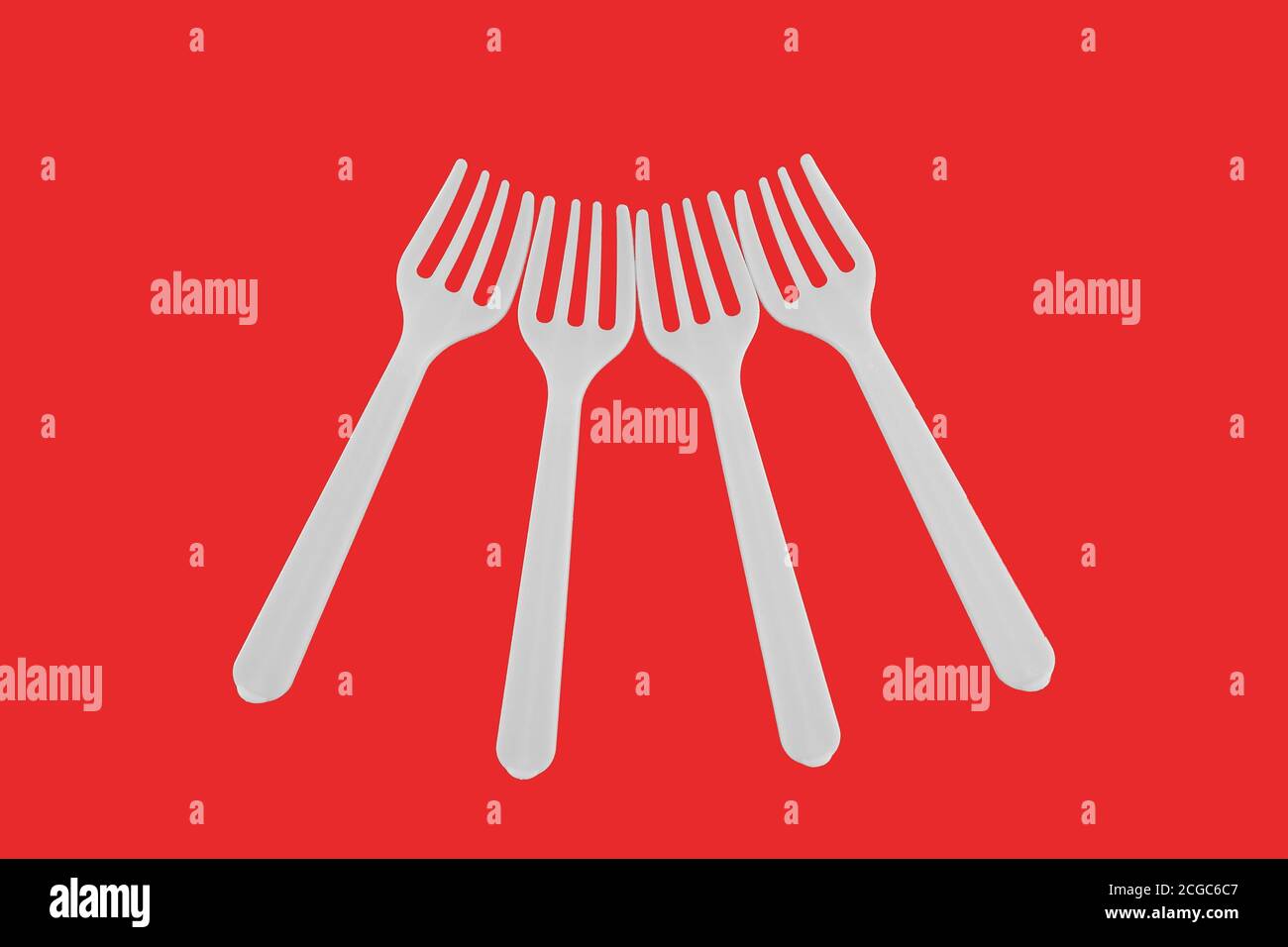 four plastic white forks on a red background Stock Photo