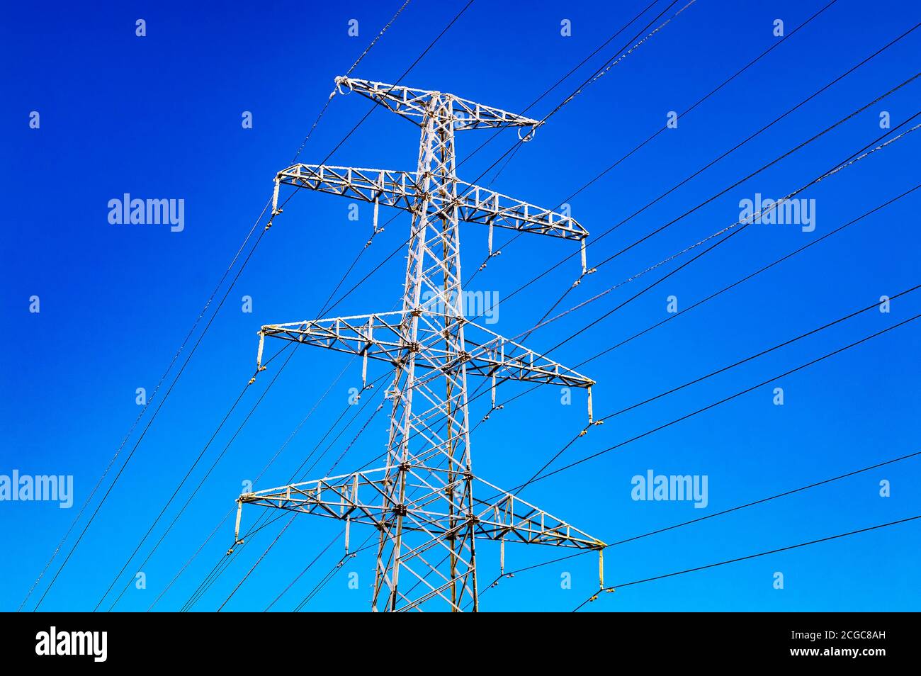 High-voltage power line and blue color metal prop with many electrical wires close up Stock Photo