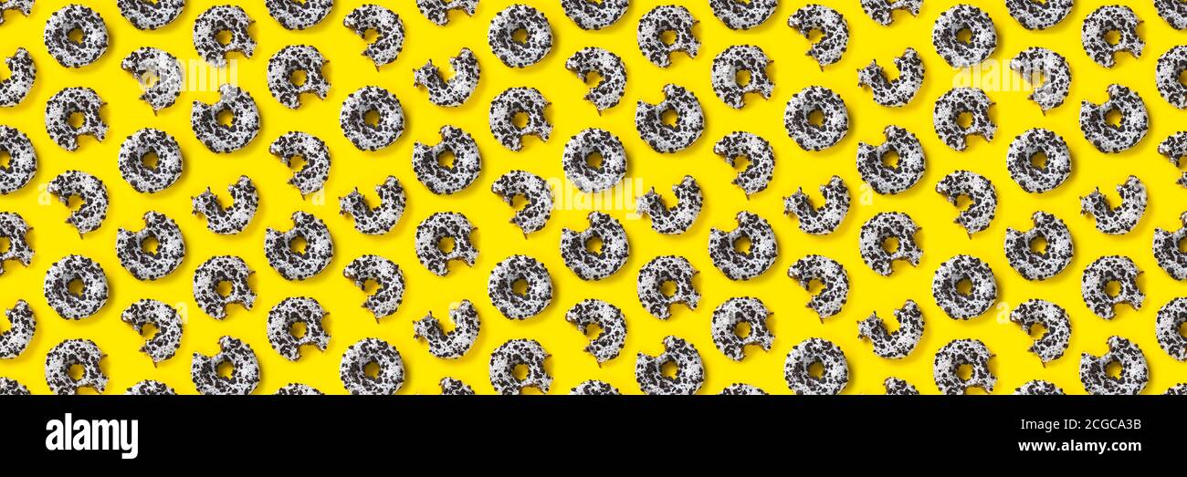 donuts on a yellow background top view. Flat lay of delicious nibbled ...