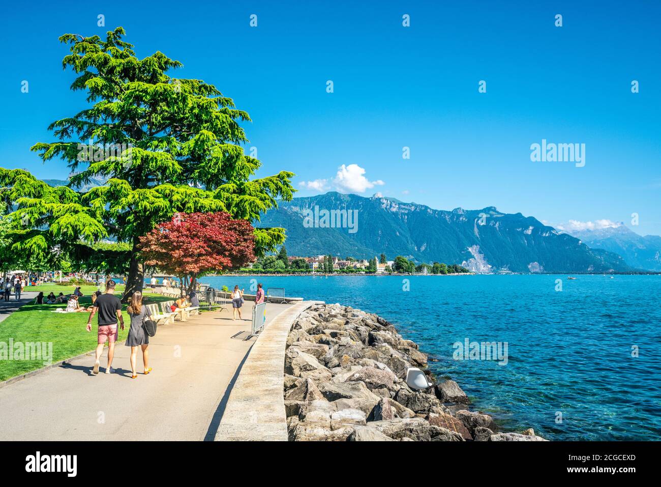 Vevey Switzerland , 4 July 2020 : People walking on Vevey lakeside pedestrian quay promenade along Lake Geneva on sunny summer day in Vaud Switzerland Stock Photo
