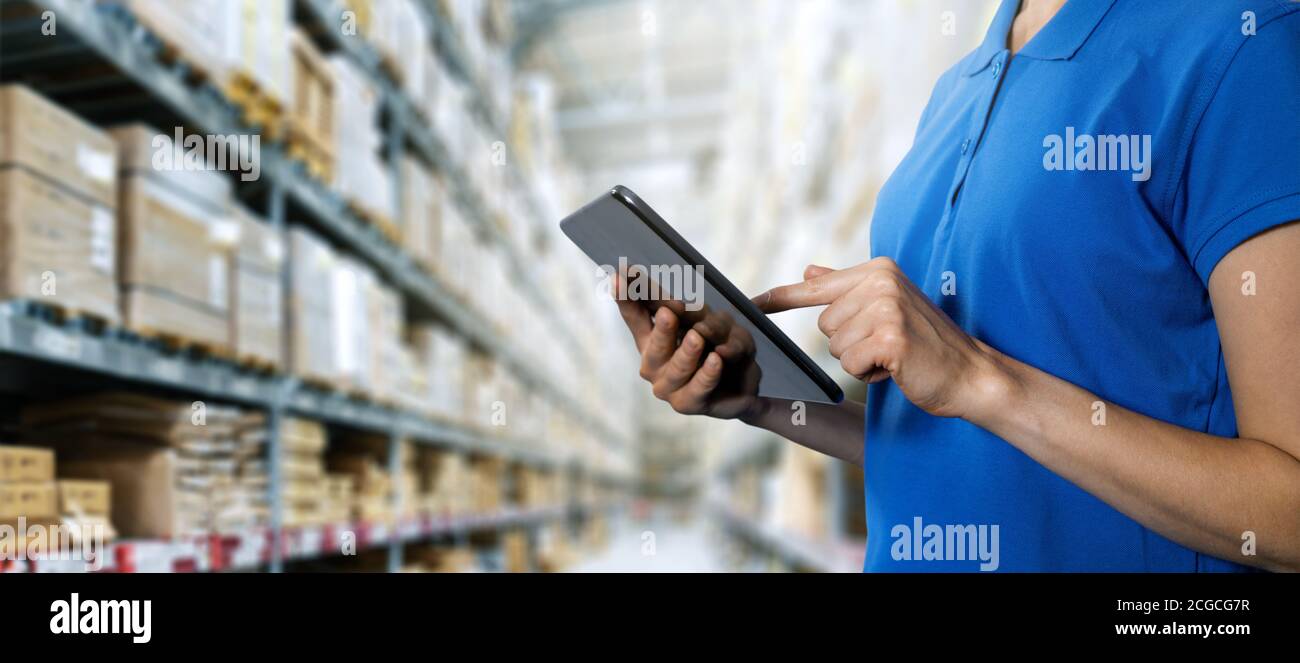 logistics service, warehouse management and inventory concept - female worker using digital tablet in warehouse. copy space Stock Photo