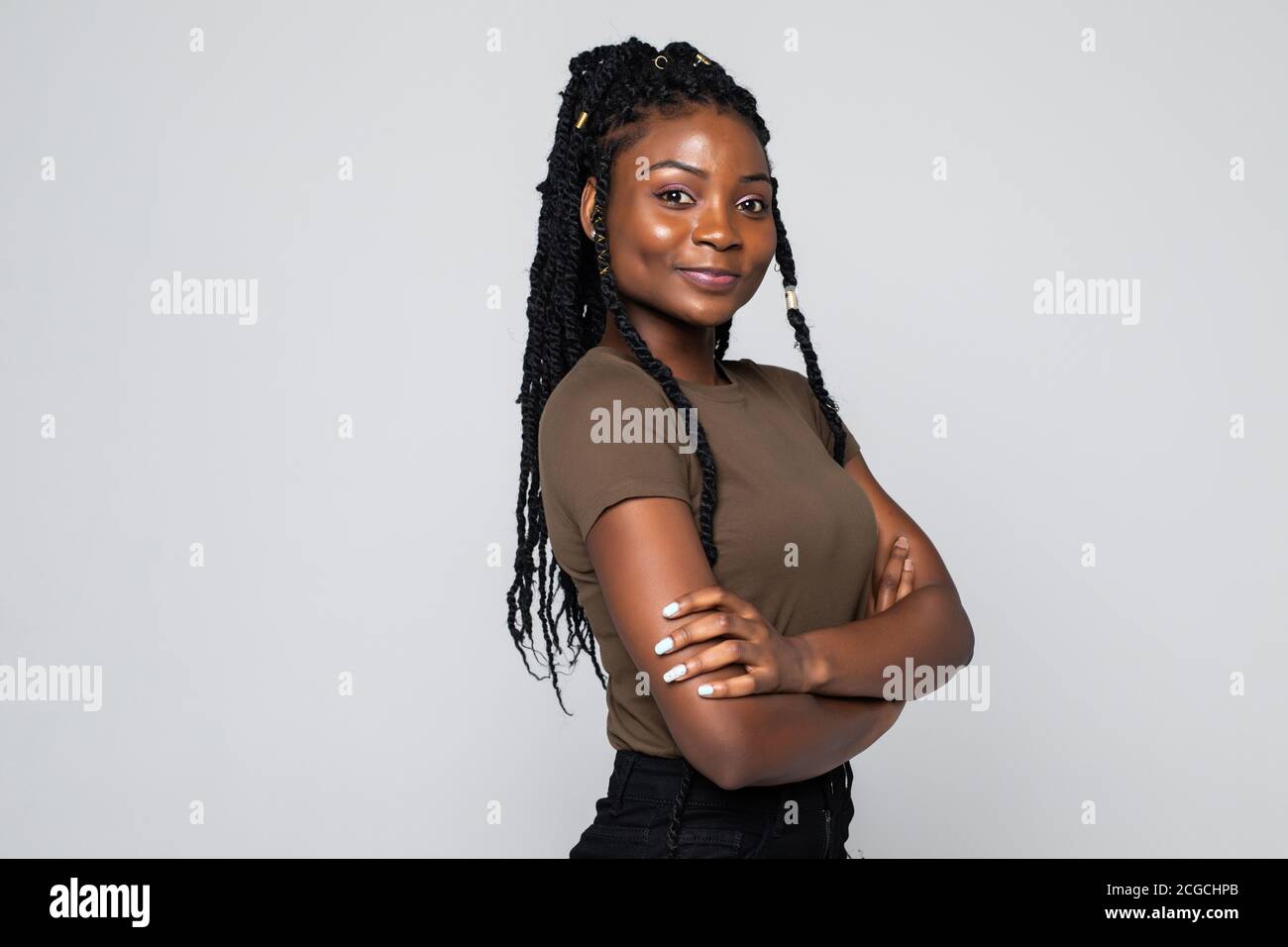Portrait of a african woman with arms folded standing over gray ...