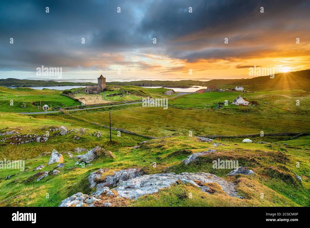 Beautiful sunset over the village of Rodel on the Isle of Harris in the Western Isles of Scotland, with St Clement's Church in the far left Stock Photo