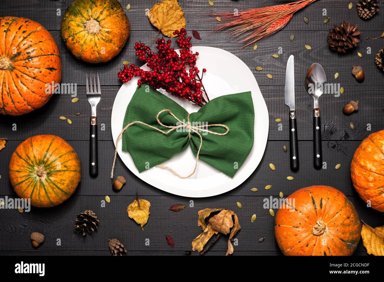 Autumn table setting with empty white plate and pumpkins. Stock Photo