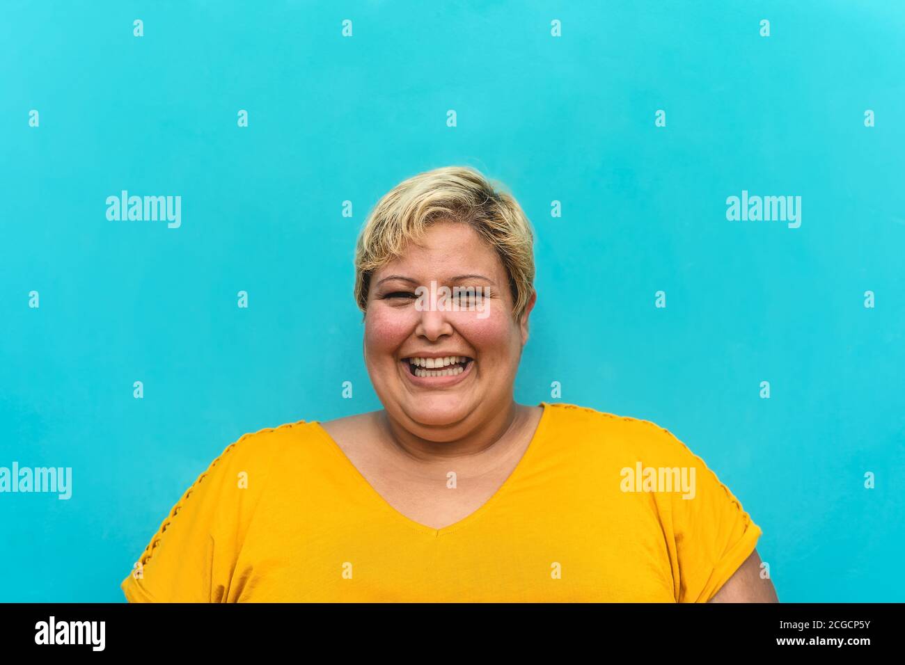 Happy plus size woman portrait - Curvy overweight model having fun smiling at camera - Over size confident person concept Stock Photo