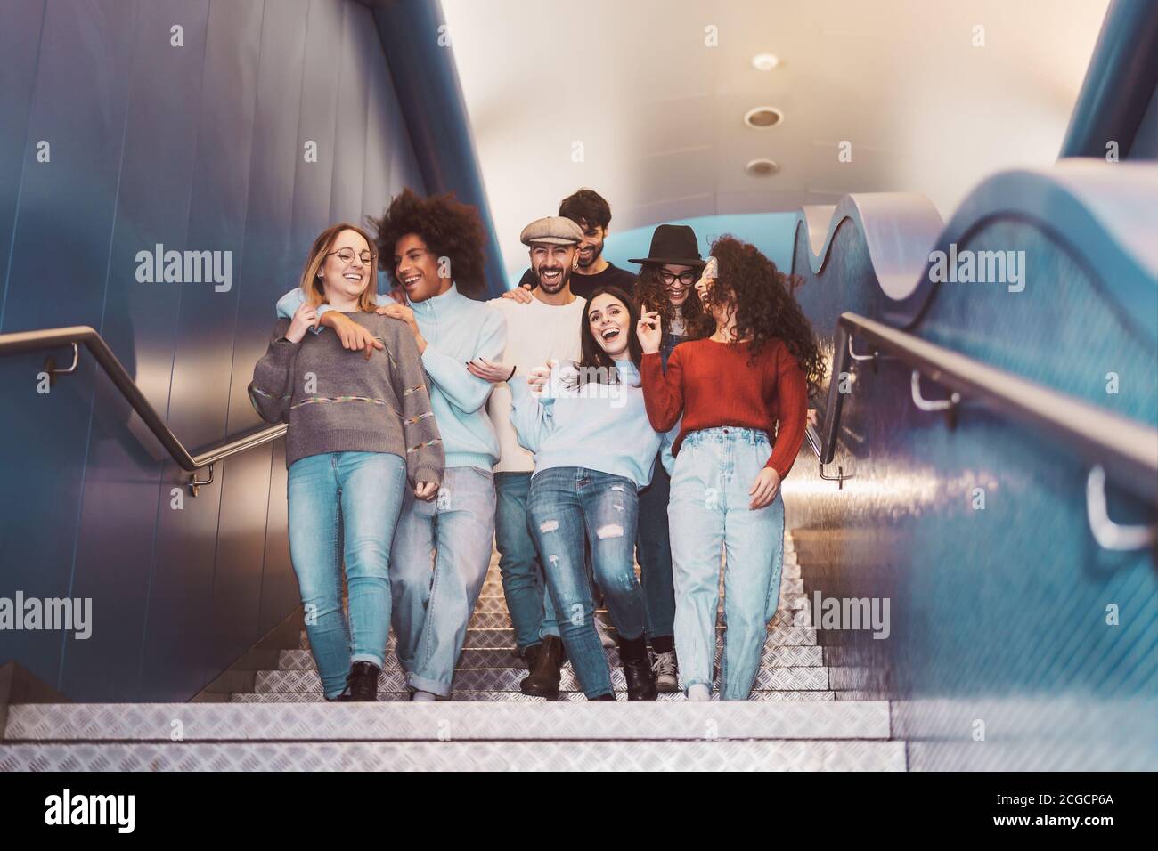 Group young friends having fun in subway underground metropolitan - Happy trendy people sharing time and laughing together Stock Photo