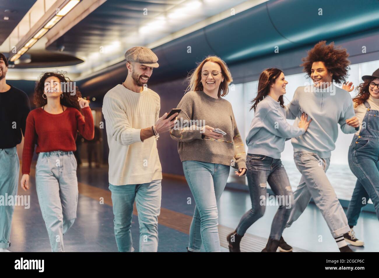 Group young friends having fun in subway underground metropolitan - Happy trendy people sharing time and laughing together Stock Photo