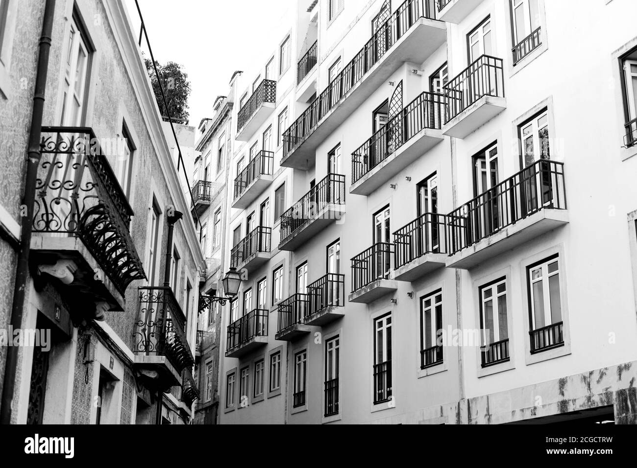 A black and white image capturing two buildings on a street in Portugal, positioned to form a striking 'V' shape. Stock Photo
