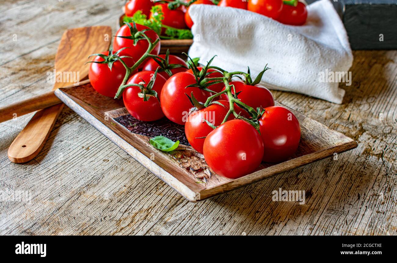 vine tomatoes on wooden rustic table Stock Photo