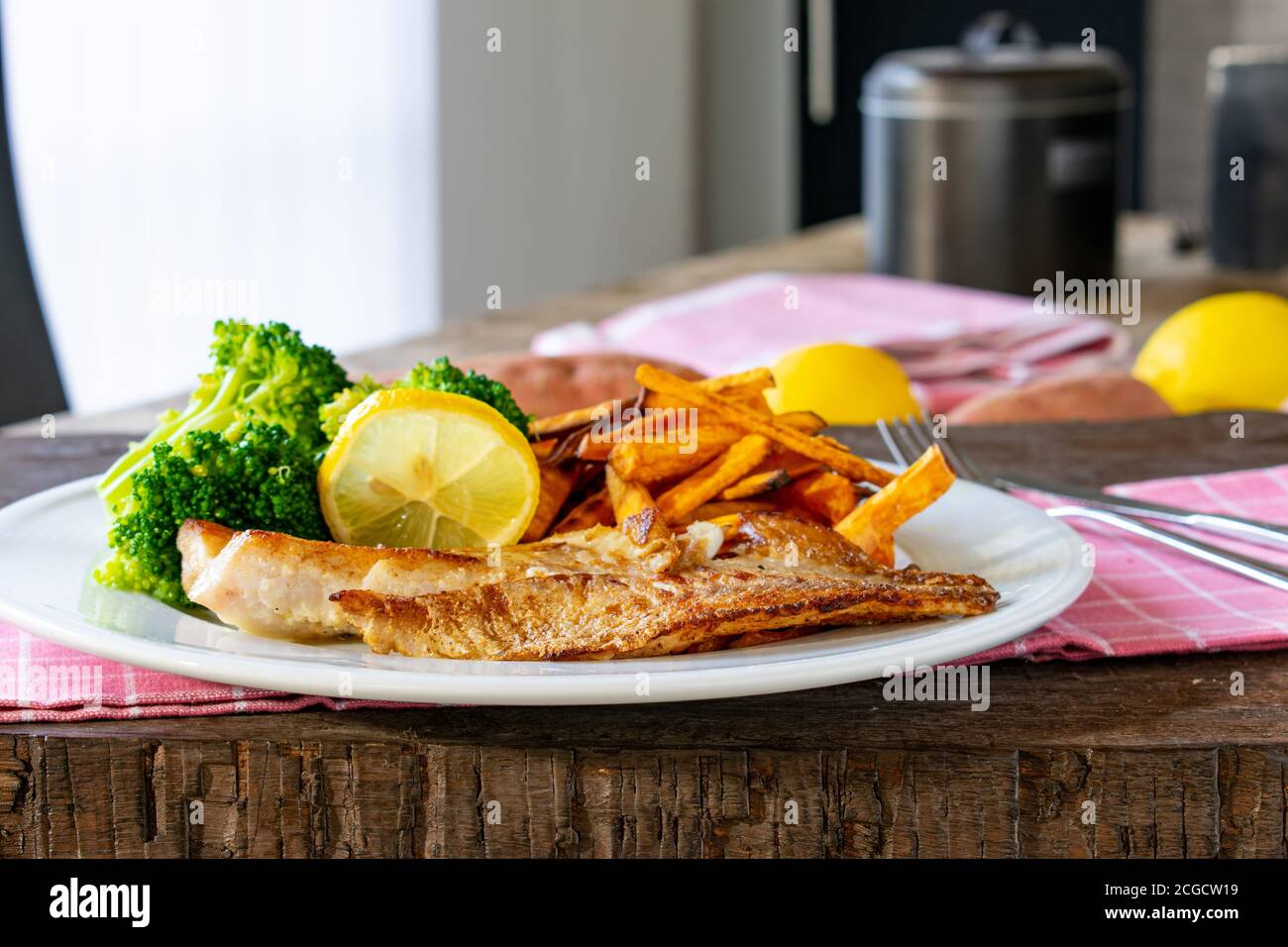 Fish with sweet potatoes and broccoli on a plate Stock Photo