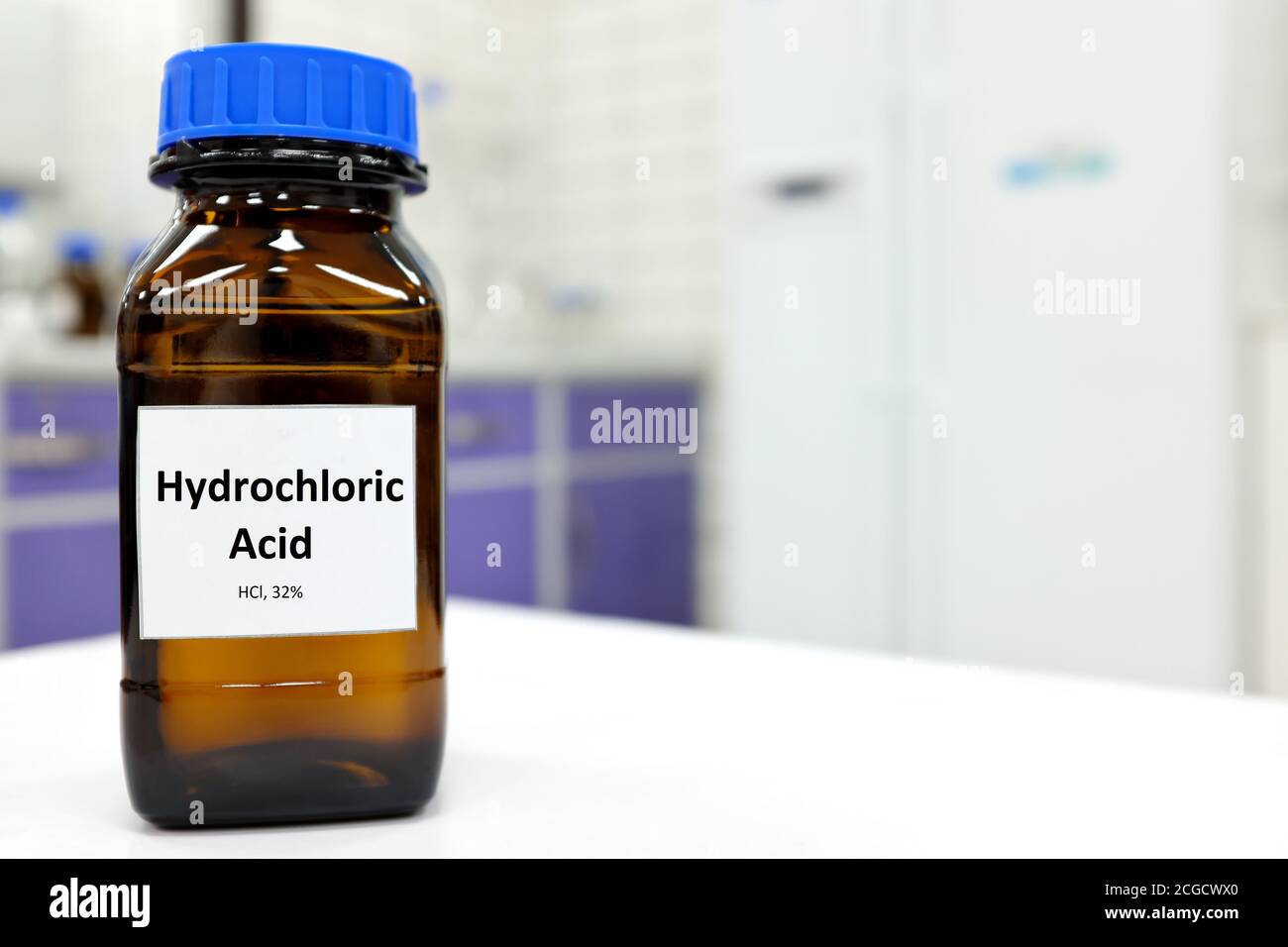 Selective focus of strong hydrochloric acid chemical in brown amber glass bottle inside a laboratory with copy space. Stock Photo