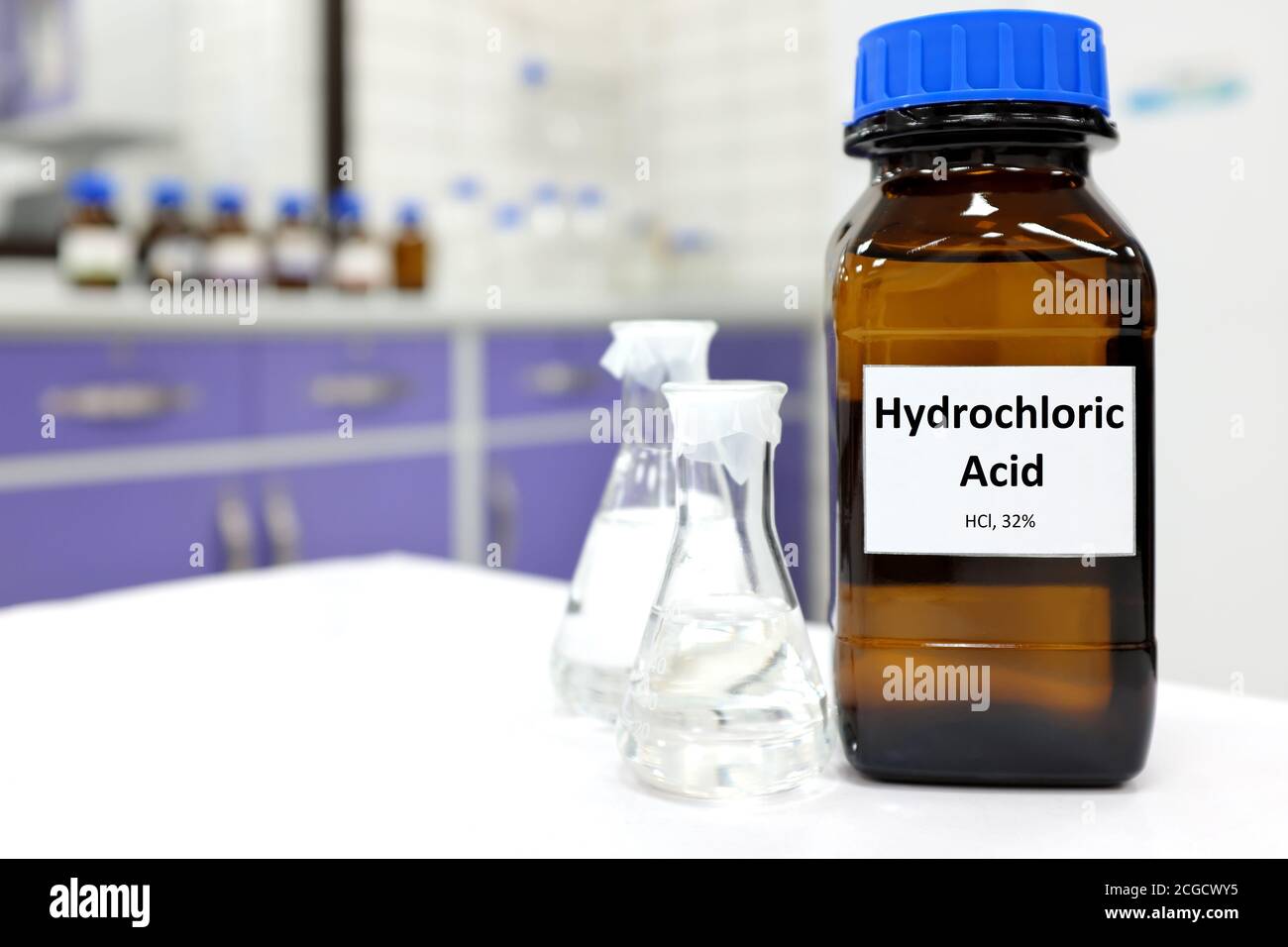 Selective focus of strong hydrochloric acid chemical in brown amber glass bottle inside a laboratory with copy space. Stock Photo