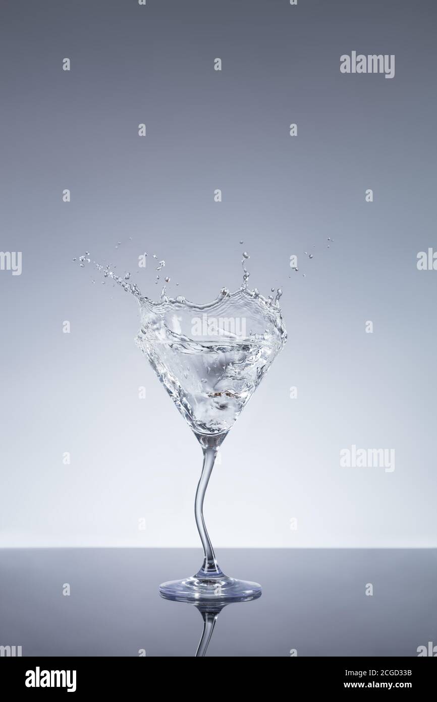 Glass of Martini drink with splashing gin around. Free space for text Stock Photo
