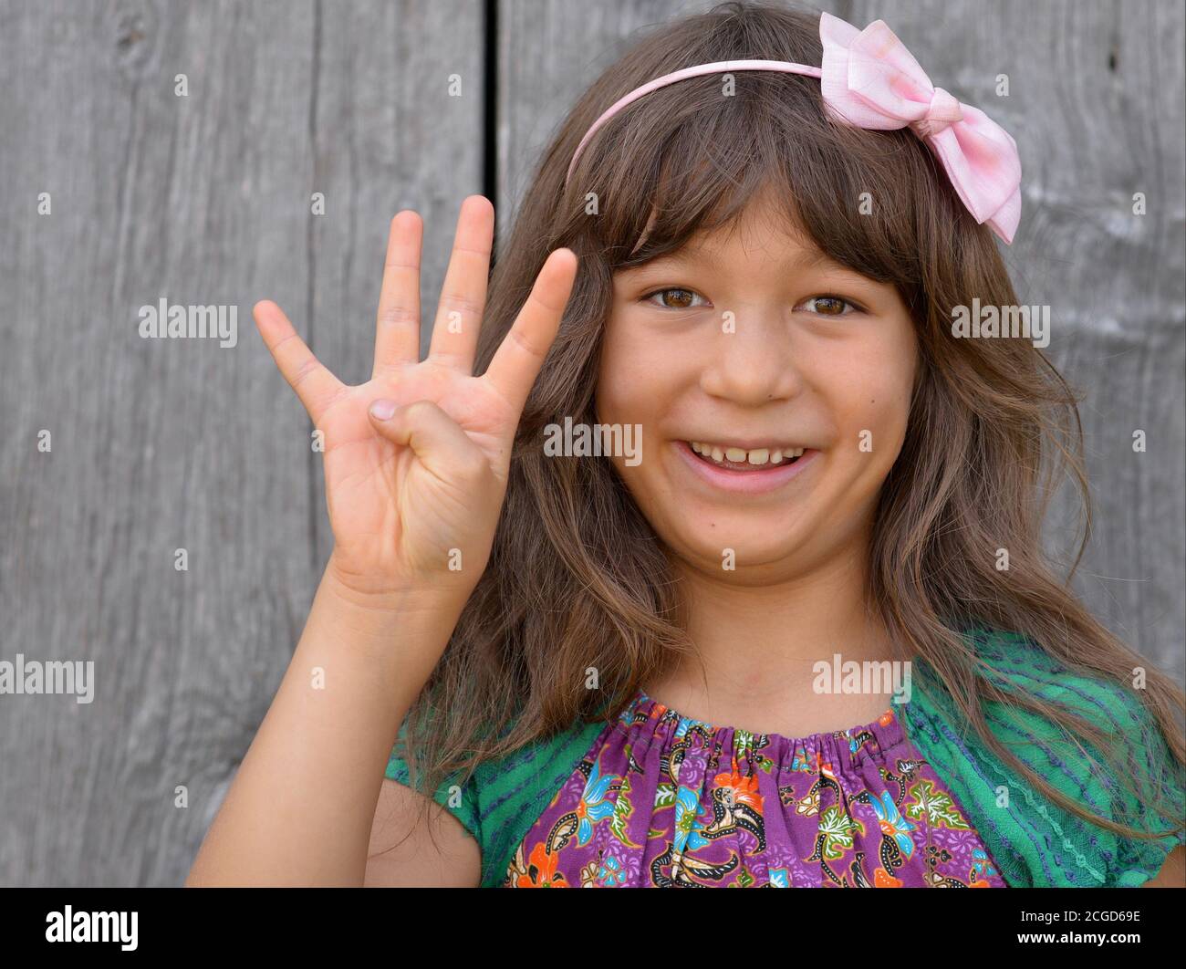 Cute mixed-race little girl (East Asian / Caucasian) shows with her right hand the Chinese hand sign for number 4 (photo series: image no. 4 of 10). Stock Photo