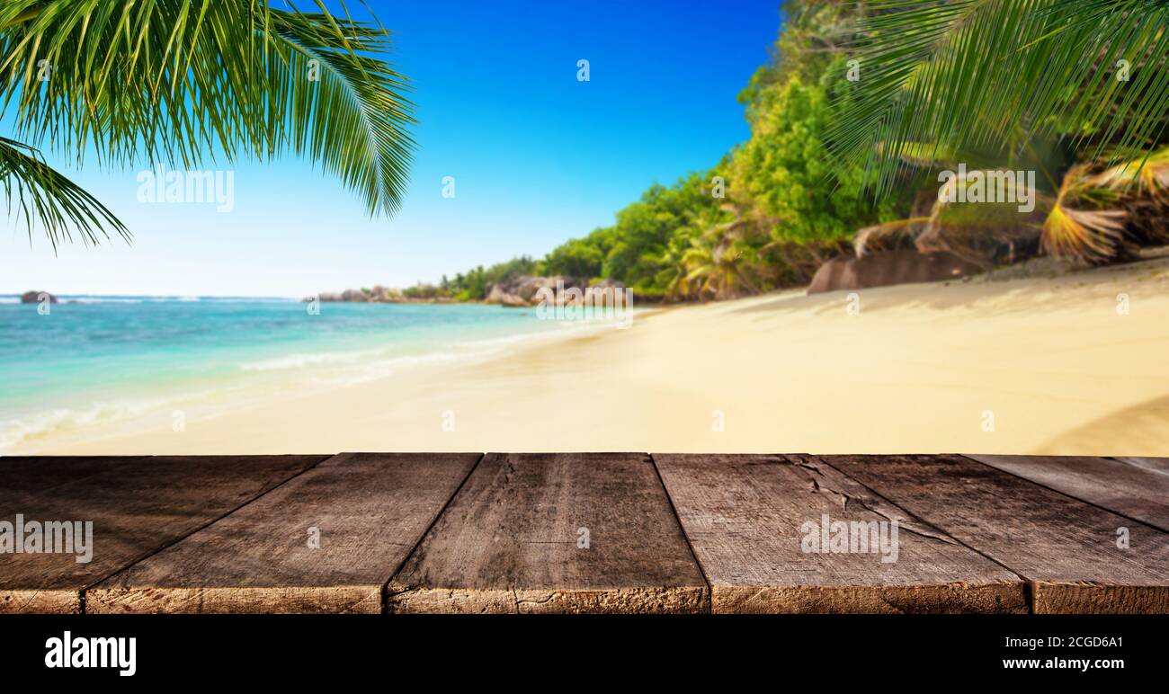 Tropical beach with empty wooden table, summer holiday background