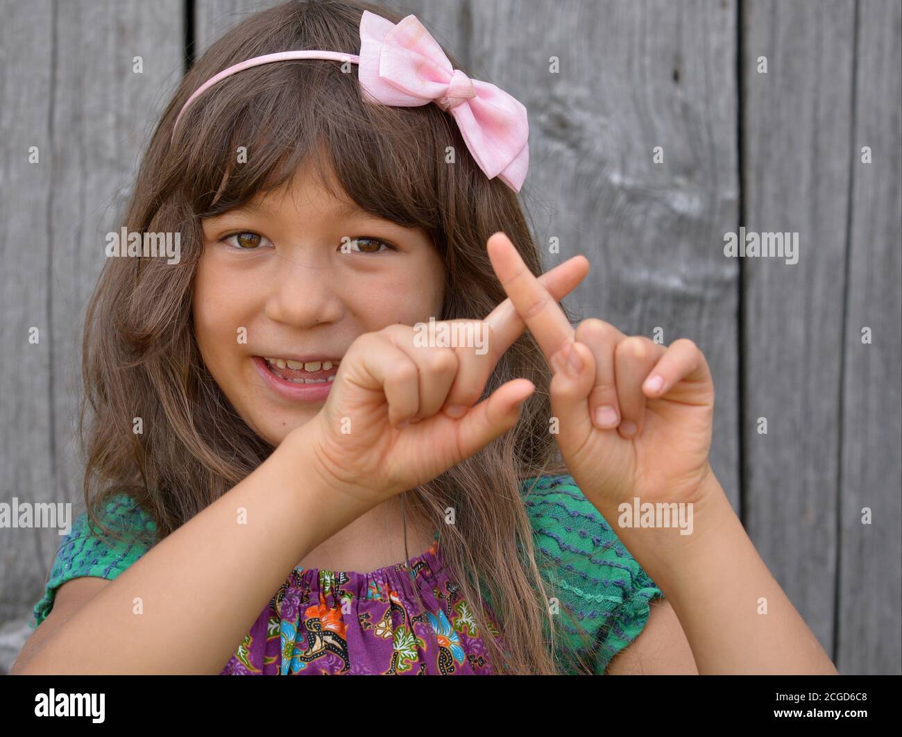 Cute mixed-race little girl (East Asian / Caucasian) shows with both hands the Chinese hand sign for number 10 (photo series: image no. 10 of 10). Stock Photo