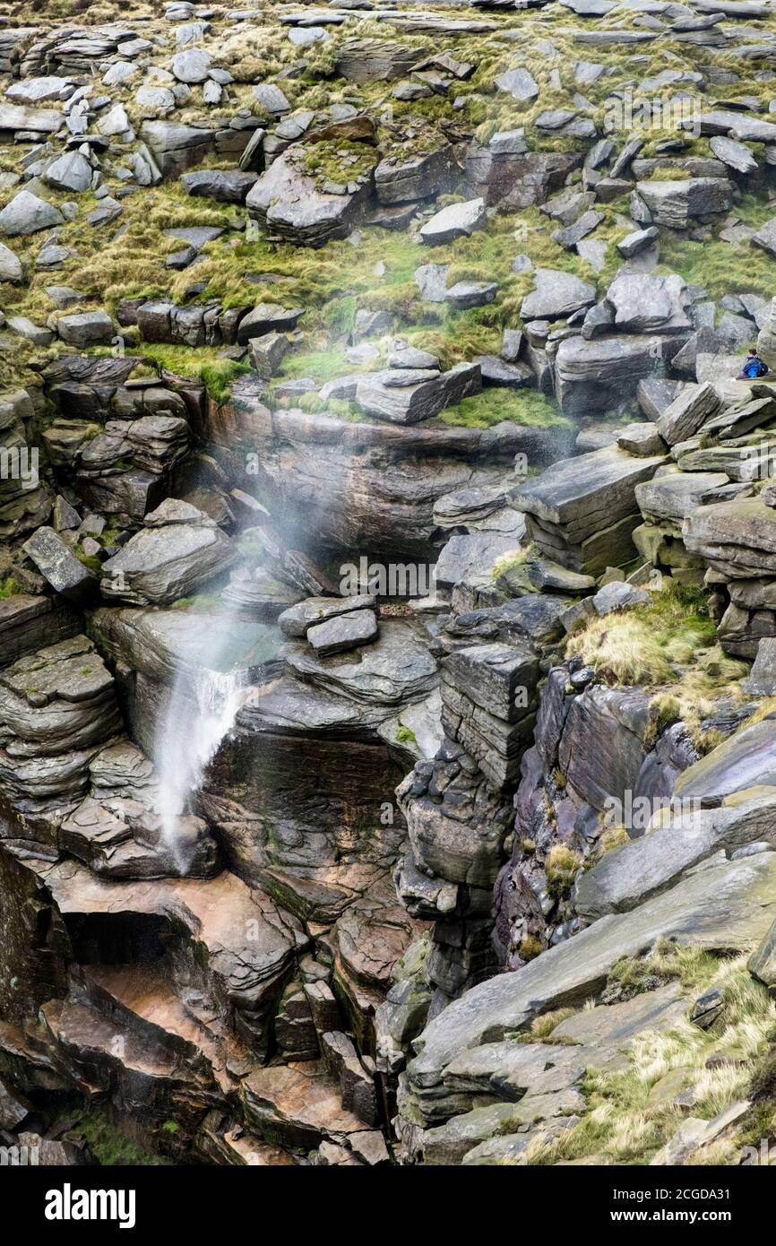 A strong westerly wind causing water flowing over Kinder Downfall to spray back up. Kinder Scout, Derbyshire, Peak District National Park, England, UK Stock Photo