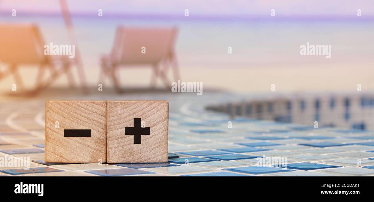 Plus and minus sign on wooden cubes on relaxed beach . Business online ...