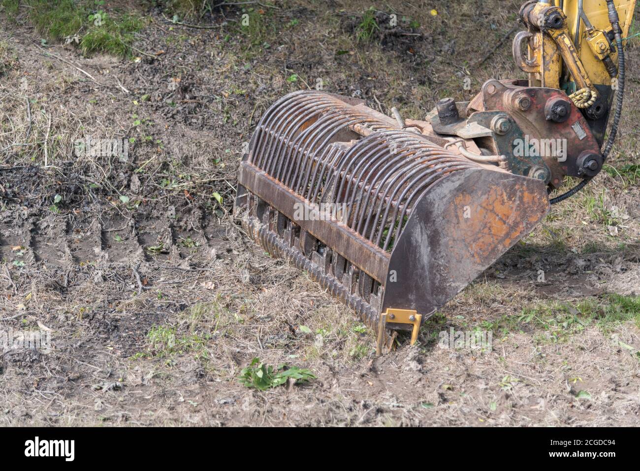 Special weed cutting dredge bucket attachment on small excavator. Used