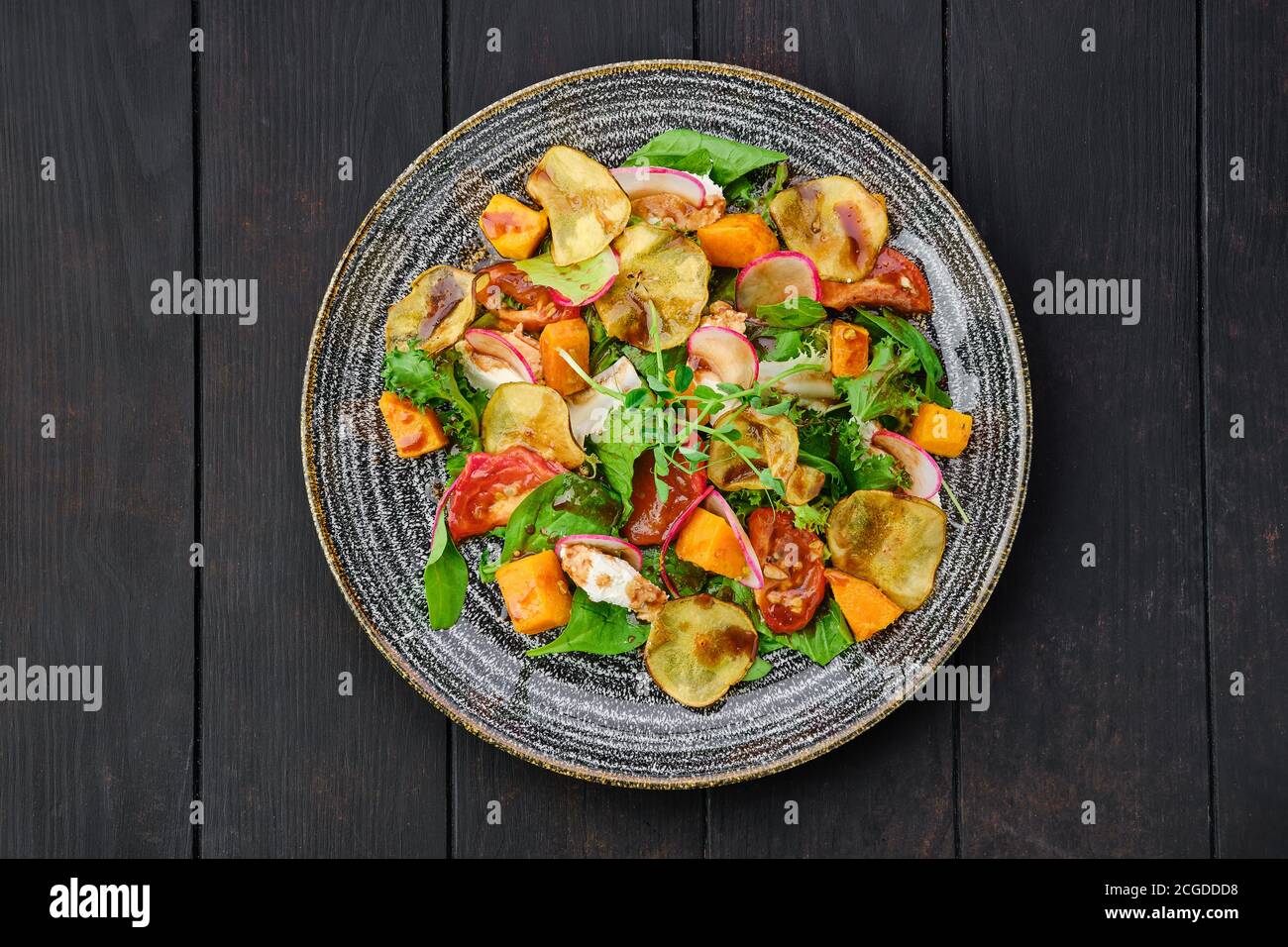 Top view of salad with soft cheese, radish, pear, pumpkin and sun dried tomato Stock Photo