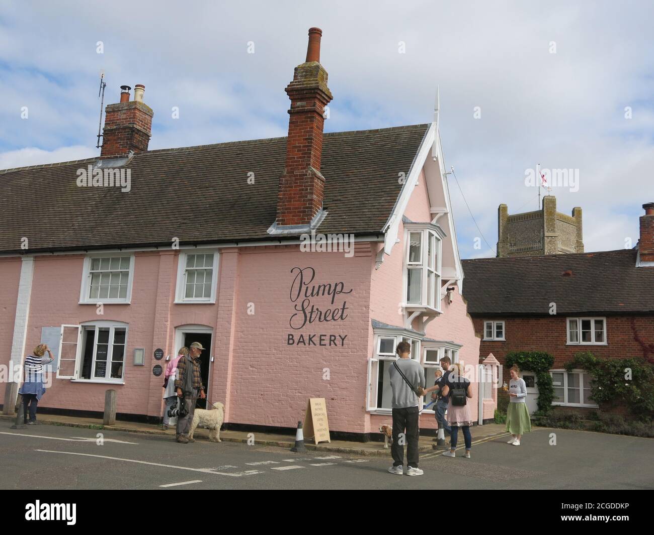 View of the Pump Street Bakery, a popular coffee shop in the Suffolk village of Orford; also an iconic building for its pink painted brick walls. Stock Photo