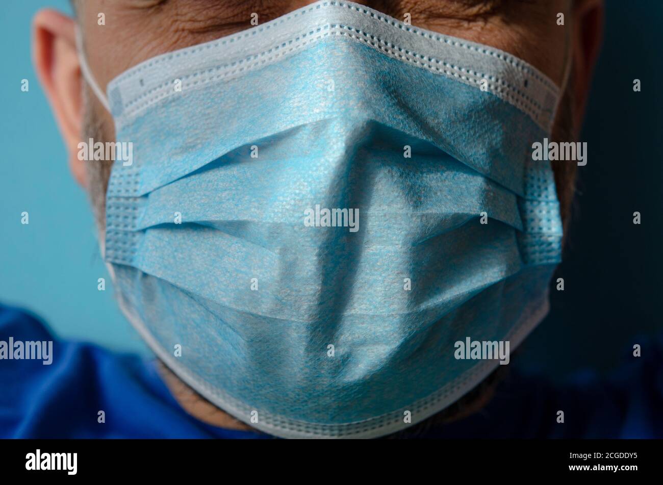 The face of a man in a blue protective medical mask Stock Photo - Alamy