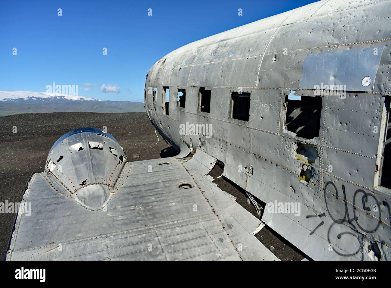 The Solheimasandur Plane Wreck in Iceland on a bright sunny day with clear blue sky.  Mýrdalsjökull above the Katla Volcano is seen in the background. Stock Photo