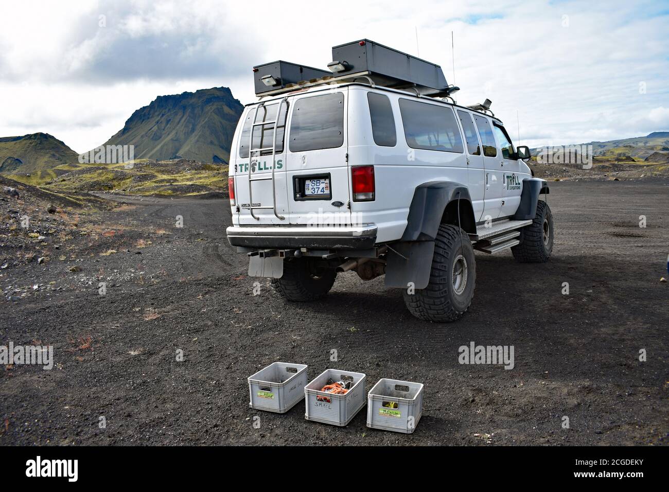 A Trool Expeditions tour company super jeep in the parking area for the Katla Ice Cave tour . The car is park on black volcanic sand on a overcast day. Stock Photo