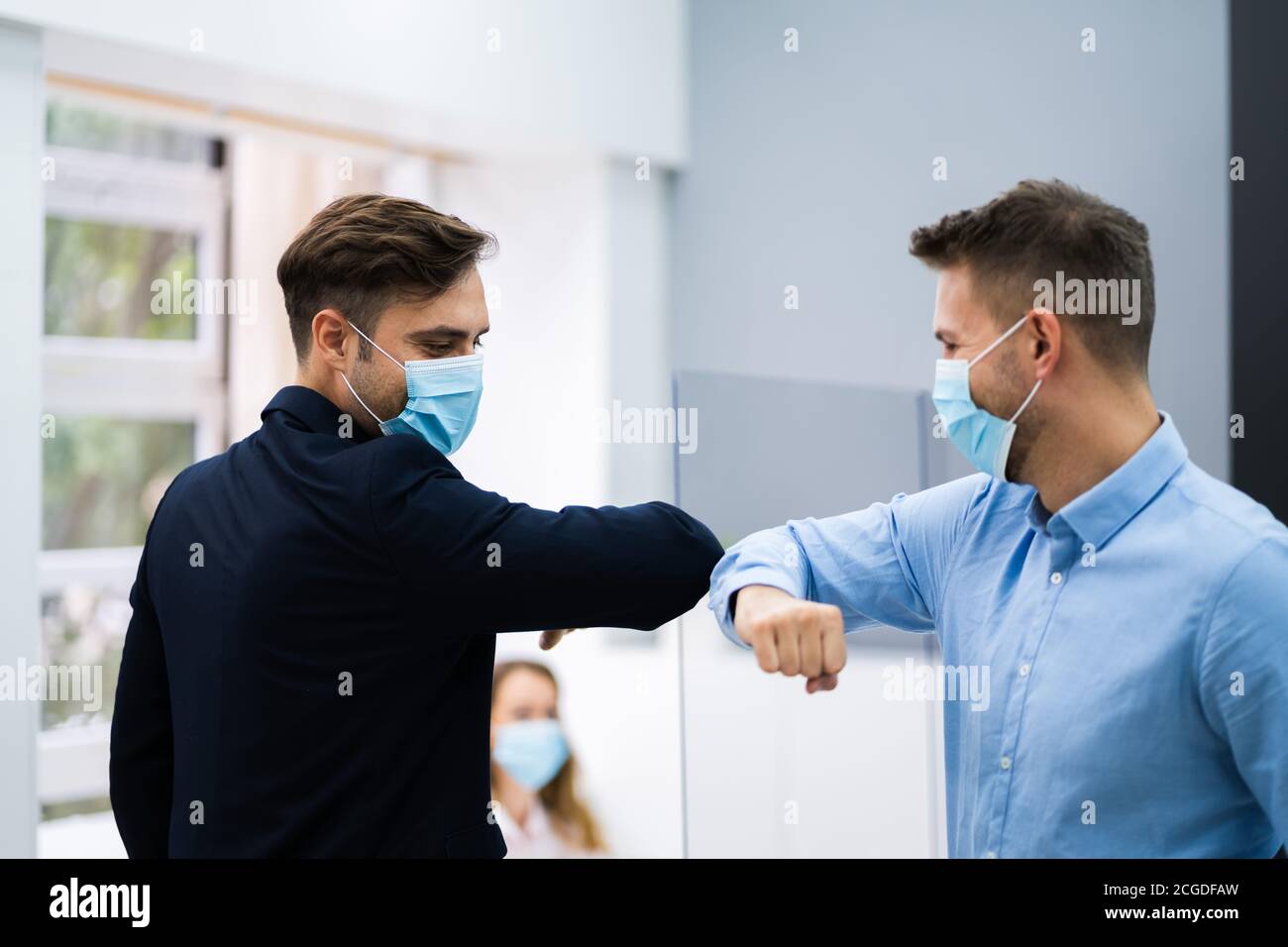 Employees Doing Elbow Bump To Avoid Flu And Stop Covid Spread Stock Photo