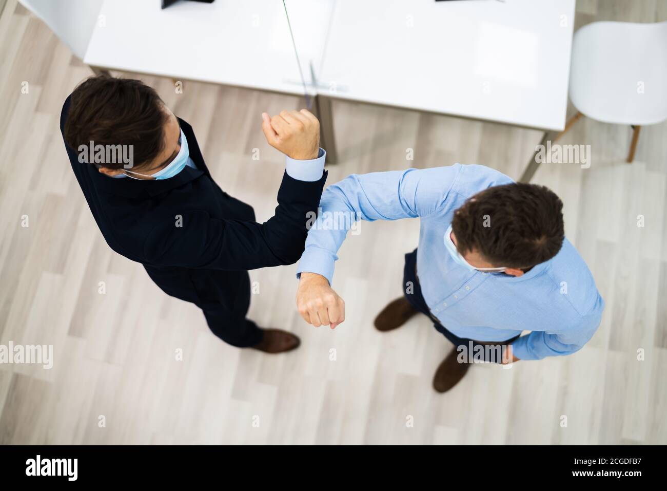 Employees Doing Elbow Bump To Avoid Flu And Stop Covid Spread Stock Photo