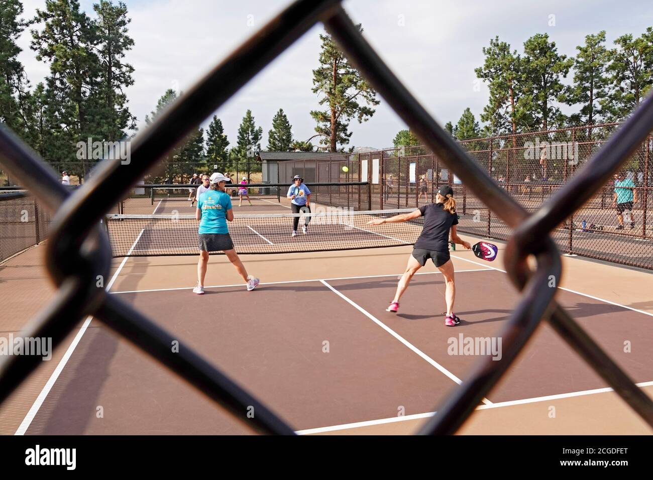Middle-aged women playing pickleball on a pickleball court at a city park in Bend, Oregon Stock Photo