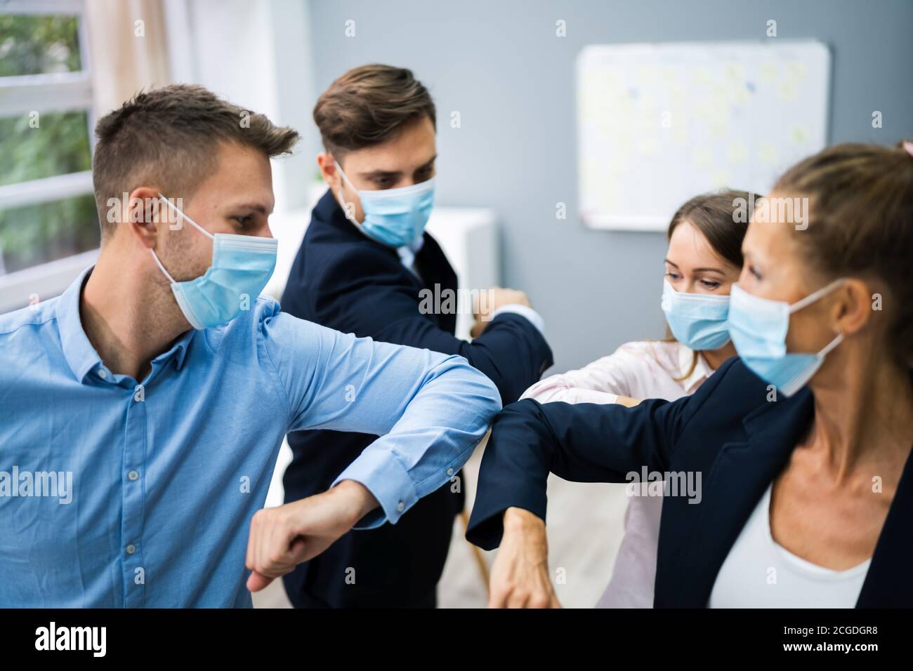 Employees Doing Elbow Bump To Avoid Flu And Stop Covid Spread Stock Photo
