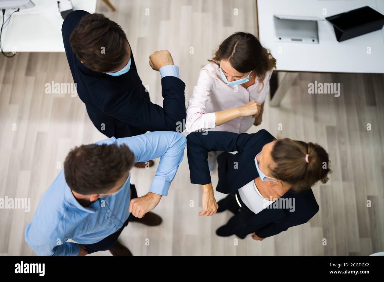 Employees Doing Elbow Bump To Avoid Flu And Stop Covid Spread Stock Photo