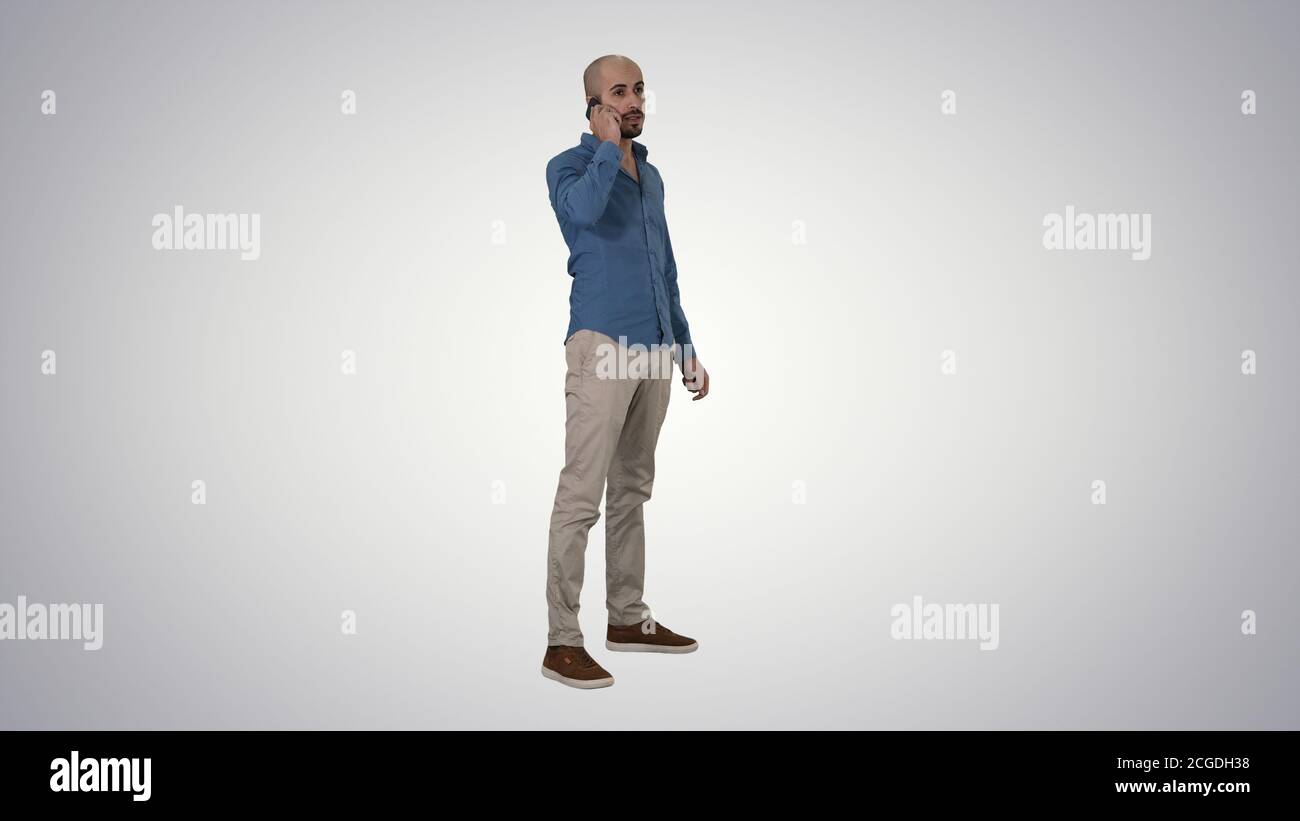 Serious arab talking on the phone on gradient background. Stock Photo
