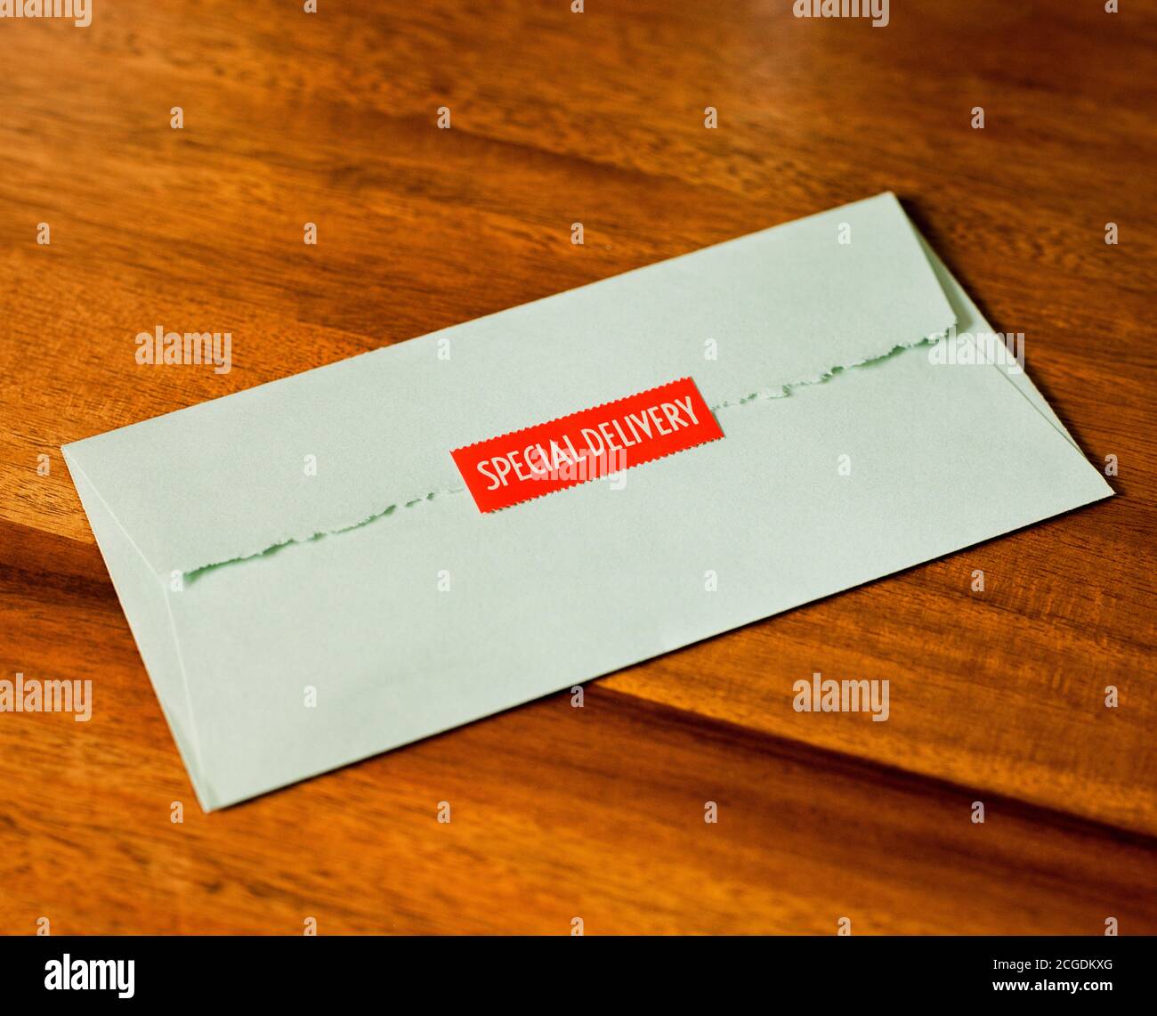 Mint green envelope with red Special Delivery stamp on walnut wood