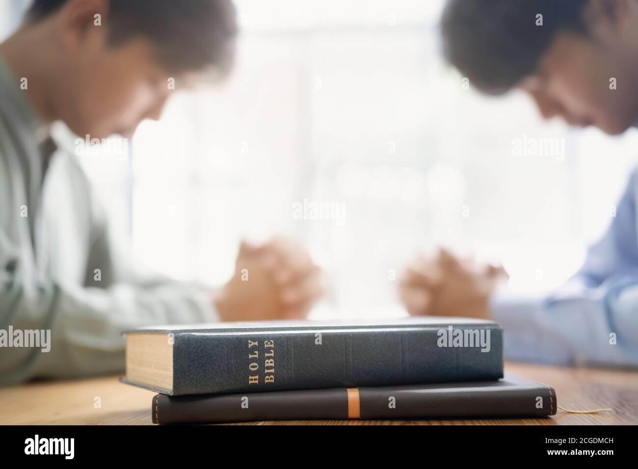 Two christian people are praying together over holy bible. Stock Photo